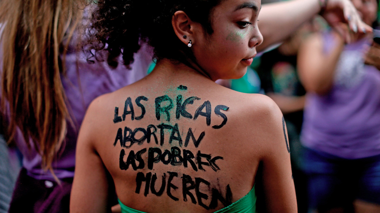 A young woman with text in Spanish written on her back that reads “Wealthy women abort, the poor die” during a pro-abortion demonstration in Buenos Aires.